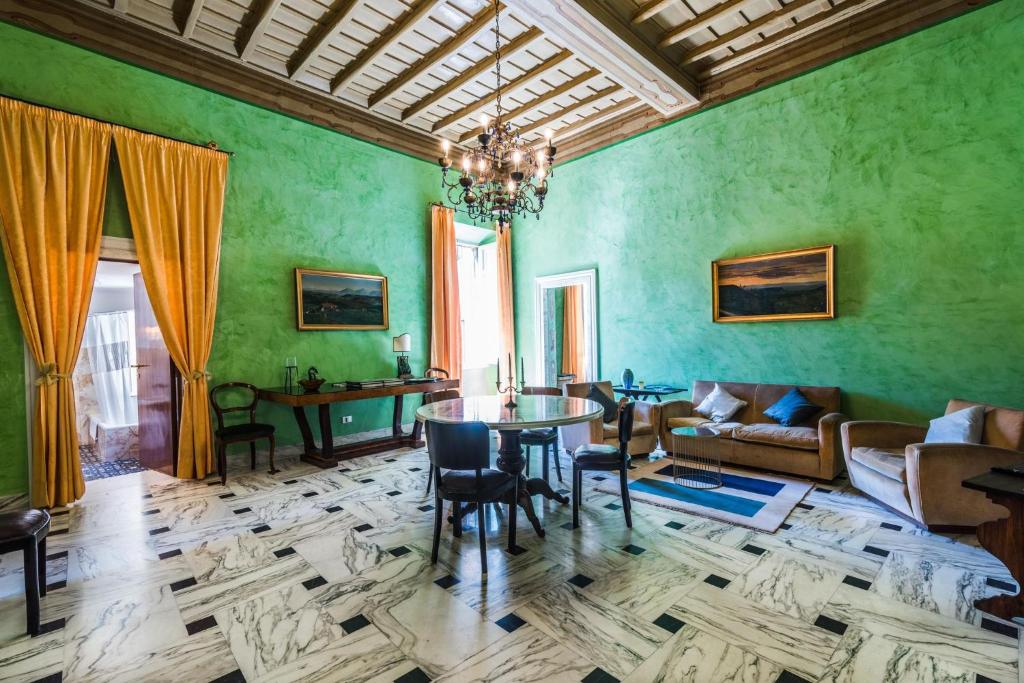 奥尔泰ART DÉCO 1920 Vicino AUTOSTRADA 40 MIN ROMA的客厅设有绿色的墙壁和桌椅