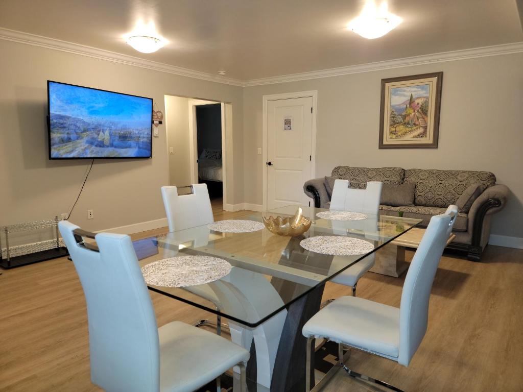 阿伯茨福德Oscar INN & 2bd Family Suite or Private Room的一间设有玻璃桌和白色椅子的用餐室
