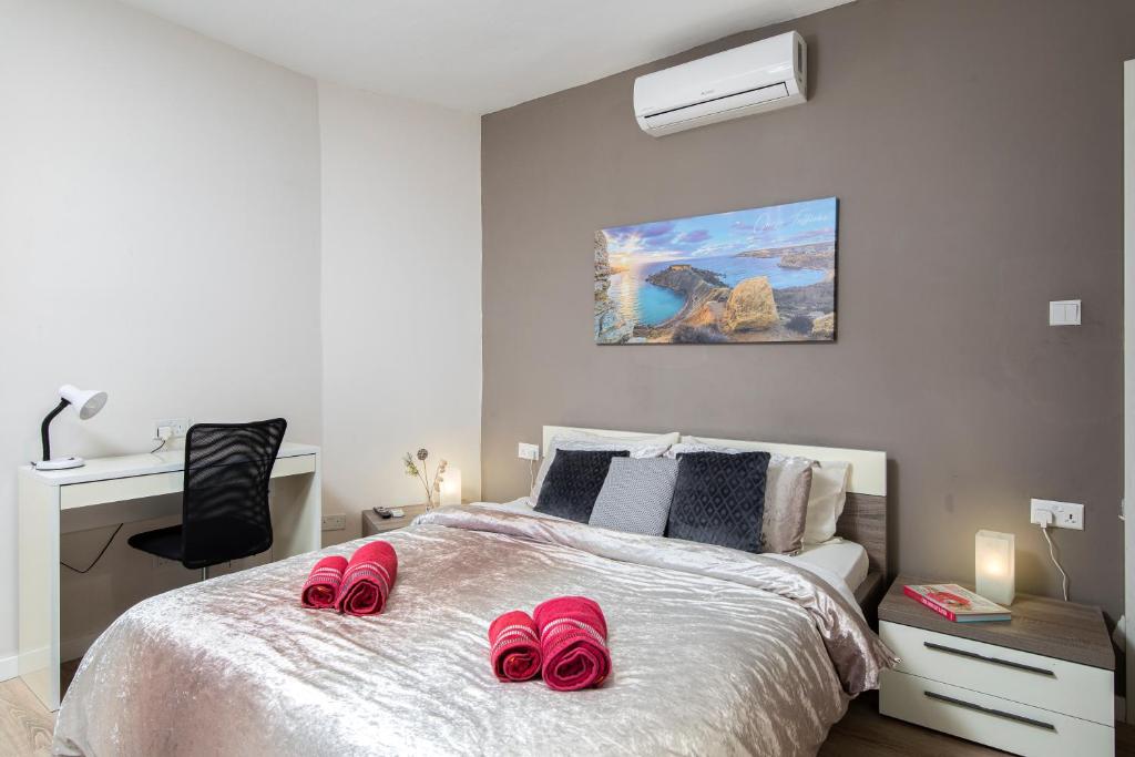 姆西达Luxury Msida Circle Suites的一间卧室配有带粉红色拖鞋的床。