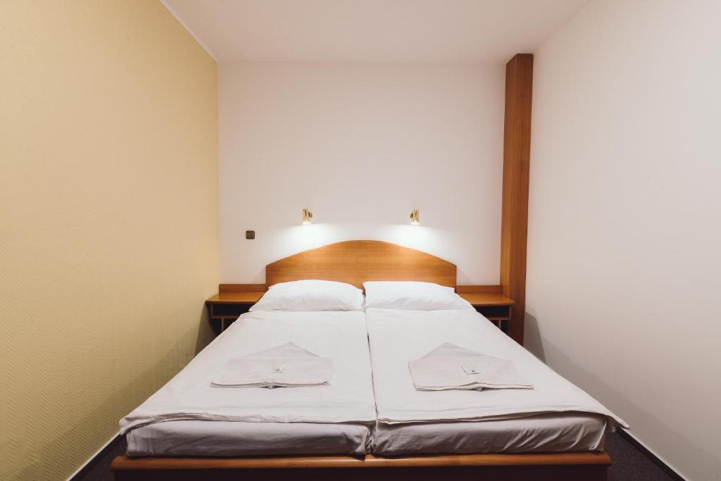Domašov安纳贺夫酒店的一间卧室配有白色床单