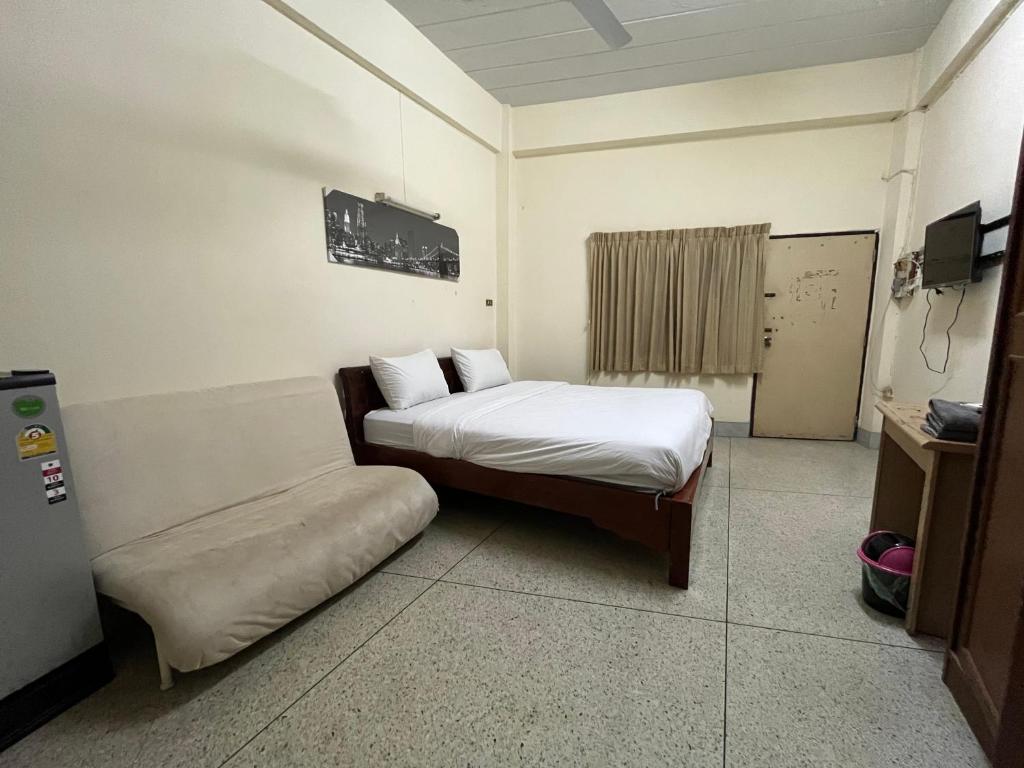 芭堤雅市中心104 Wanna Apartment的一间卧室配有一张床和一个沙发