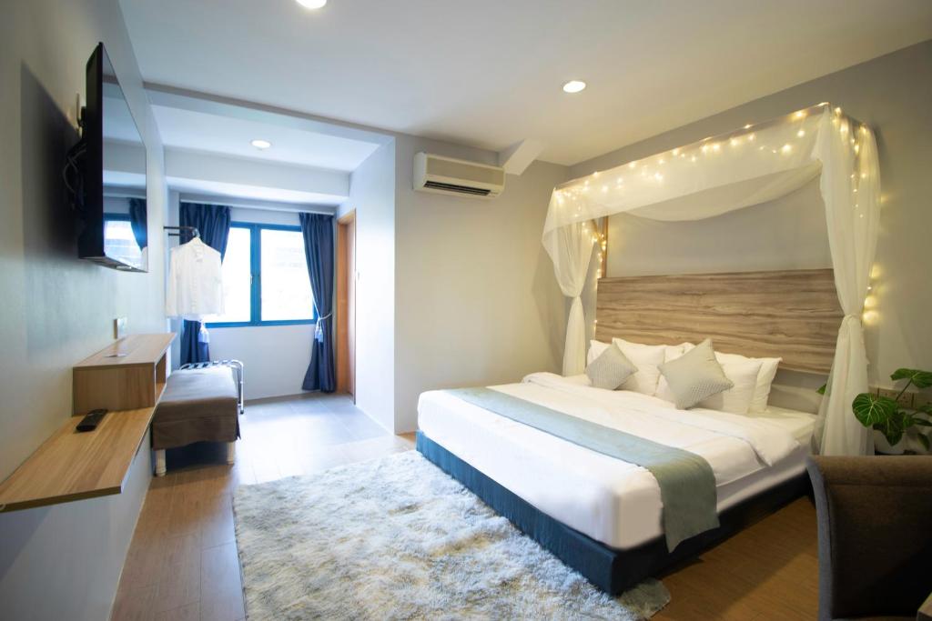 新加坡Victoria Hotel a NuVe Group Collection的一间卧室配有一张带天蓬的床