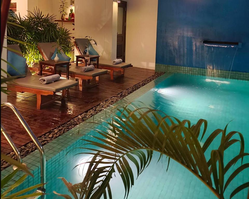 暹粒Baahu Villa的游泳池旁带躺椅的游泳池