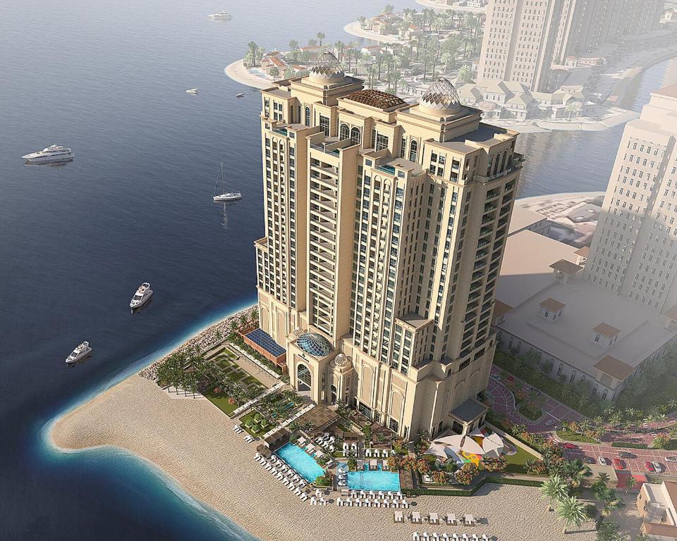 多哈Four Seasons Resort and Residences at The Pearl - Qatar的水边一座大建筑的空中景观