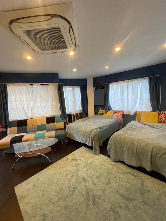大阪spaceMU的一间卧室设有两张床、一张沙发和窗户。