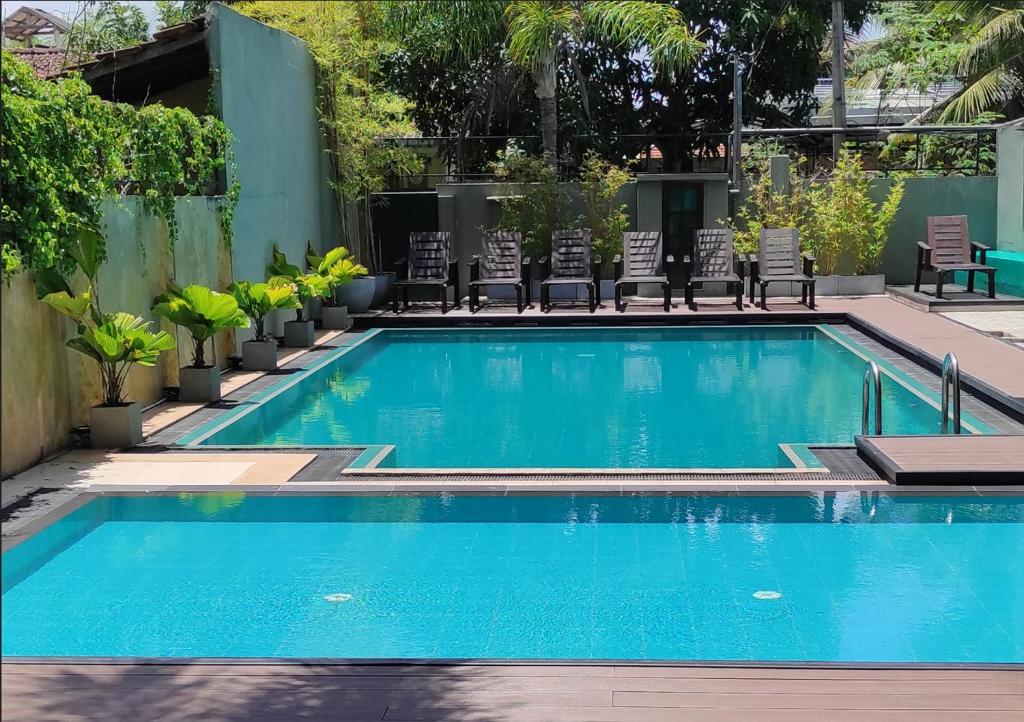 尼甘布Morning Star Resorts的一个带椅子的大型游泳池和一个游泳池