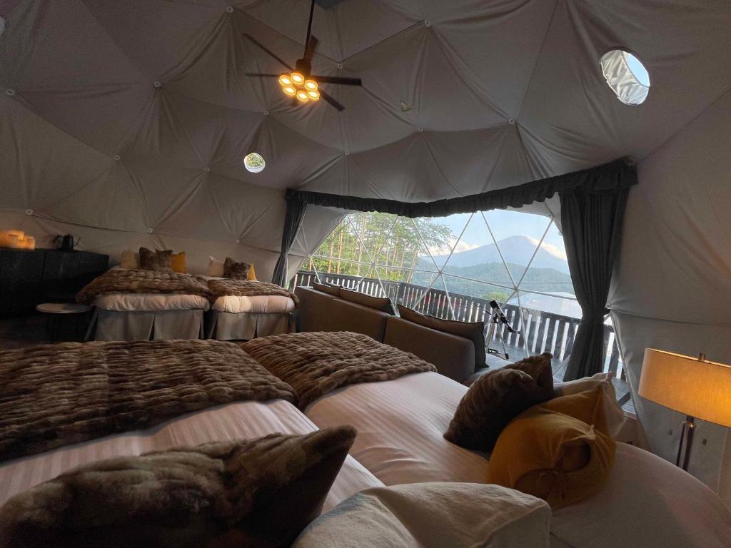 富士河口湖TOCORO. Mt.Fuji CAMP&GLAMPING的帐篷内一间卧室,配有四张床