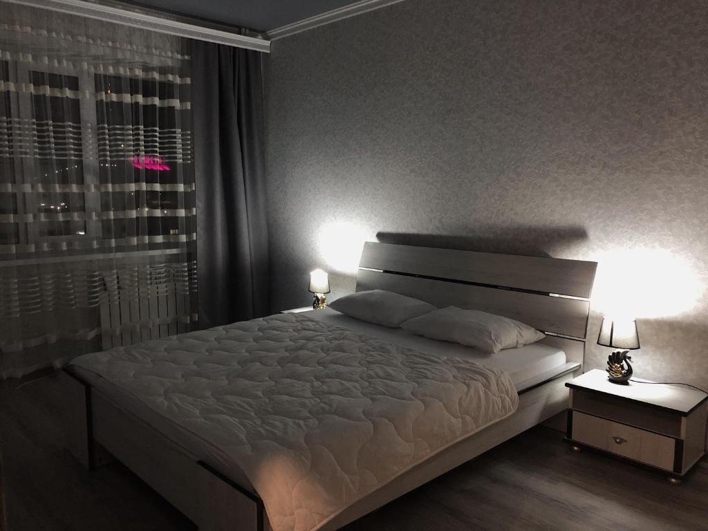 科克舍套Квартира в центре города посуточно, понедельно的一间卧室配有一张带两盏灯的床和一扇窗户。