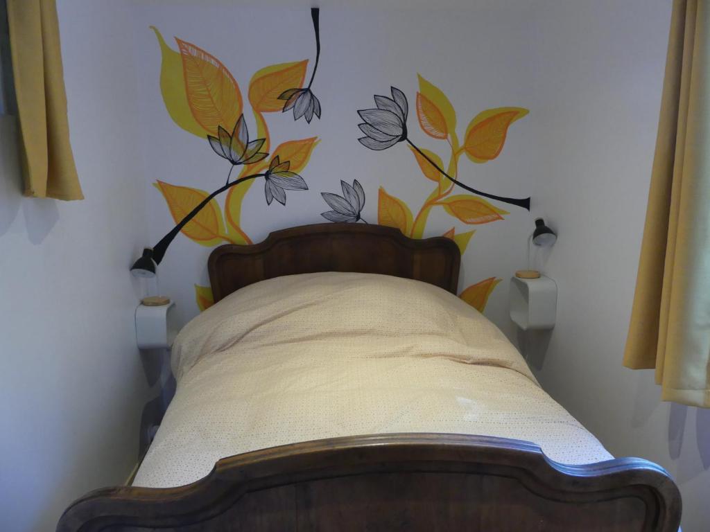 维伊勒佩Maison de village au calme axe Annecy - Genève的卧室配有一张挂着花壁画的床。