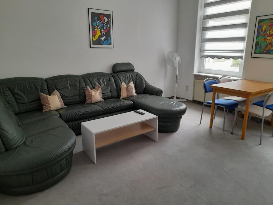 茨维考Schöne Wohnung für Monteure und sonstige Reisende的客厅配有黑色真皮沙发和桌子