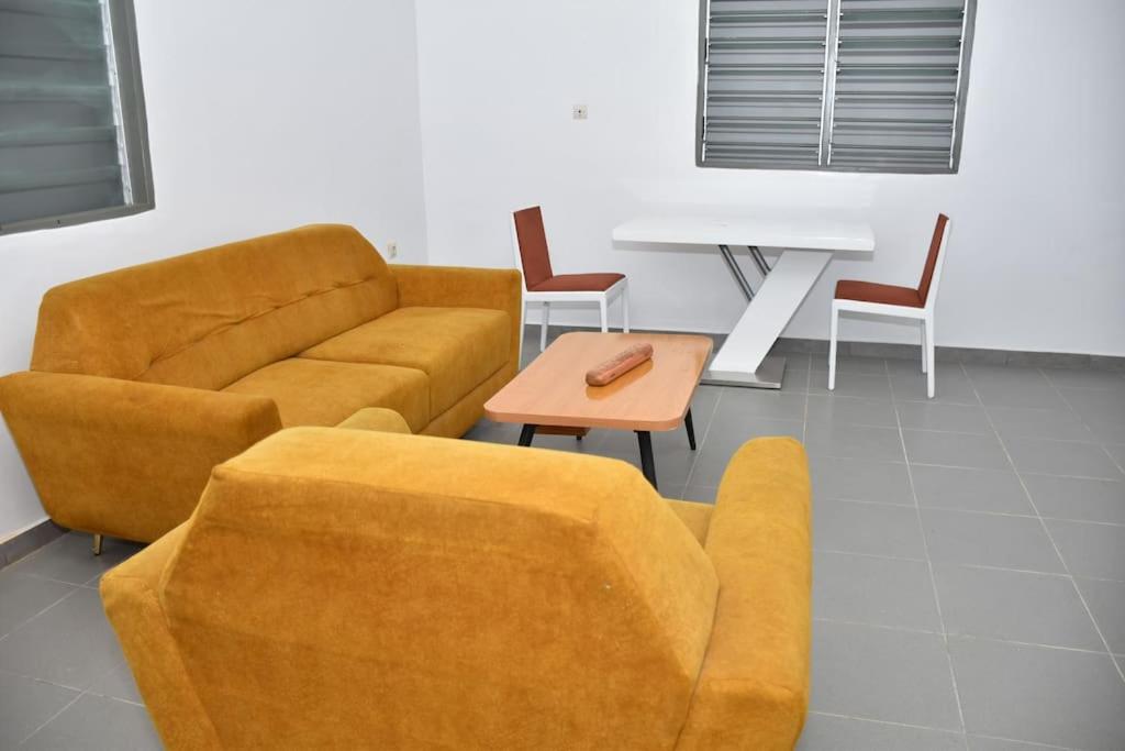 科托努Tranquillité Cotonou的客厅配有沙发和桌椅