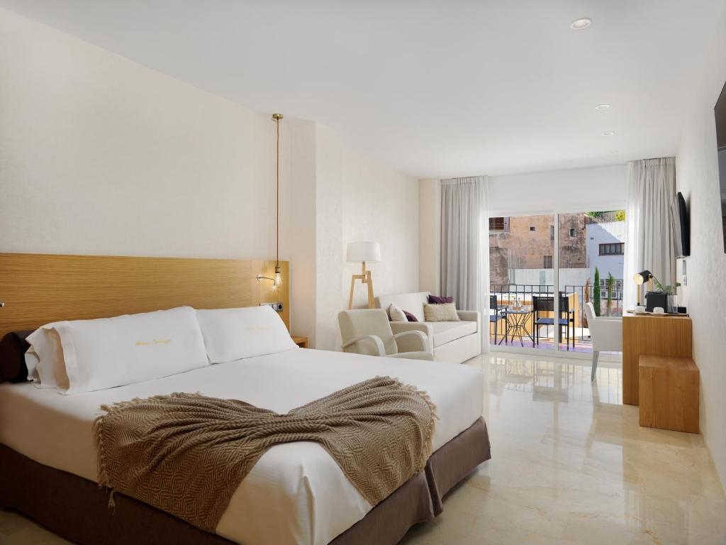 马略卡岛帕尔马萨拉托加酒店的一间带大床的卧室和一间客厅