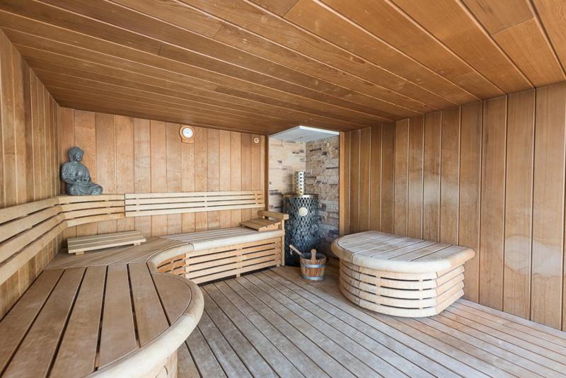 阿纲尔赫姆Vlaamse Ardennen Vakantiehuis Casa Caliente met wellness的一间带两个长椅和炉灶的桑拿浴室