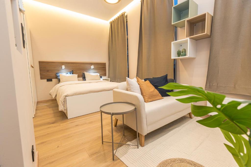 布鲁塞尔Golden Dove Luxury Aparts的一间卧室配有一张床、一张沙发和一张桌子
