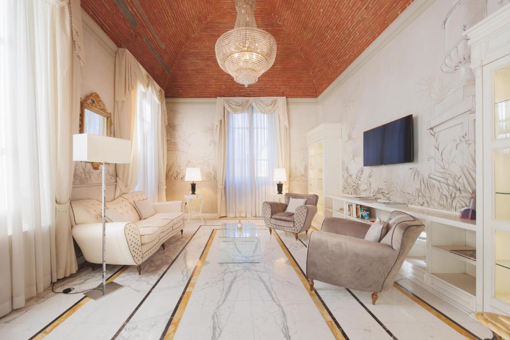 佛罗伦萨大使馆酒店的客厅配有沙发、椅子和电视
