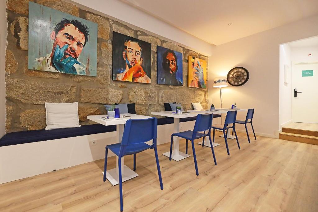 波尔图FLH Porto Downtown GuestHouse的配有桌椅和壁画的房间