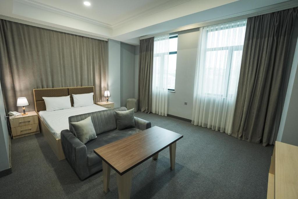 巴库Ogguesto Hotel的酒店客房配有床、沙发和桌子。
