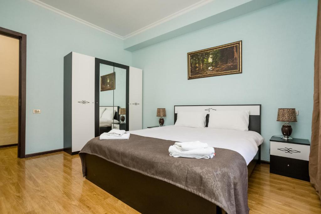第比利斯Rustaveli Three Bedroom Apartment with Amazing views的一间卧室配有一张大床和两条毛巾