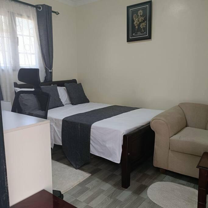 内罗毕Sharz place的一间卧室配有一张床、一张沙发和一把椅子