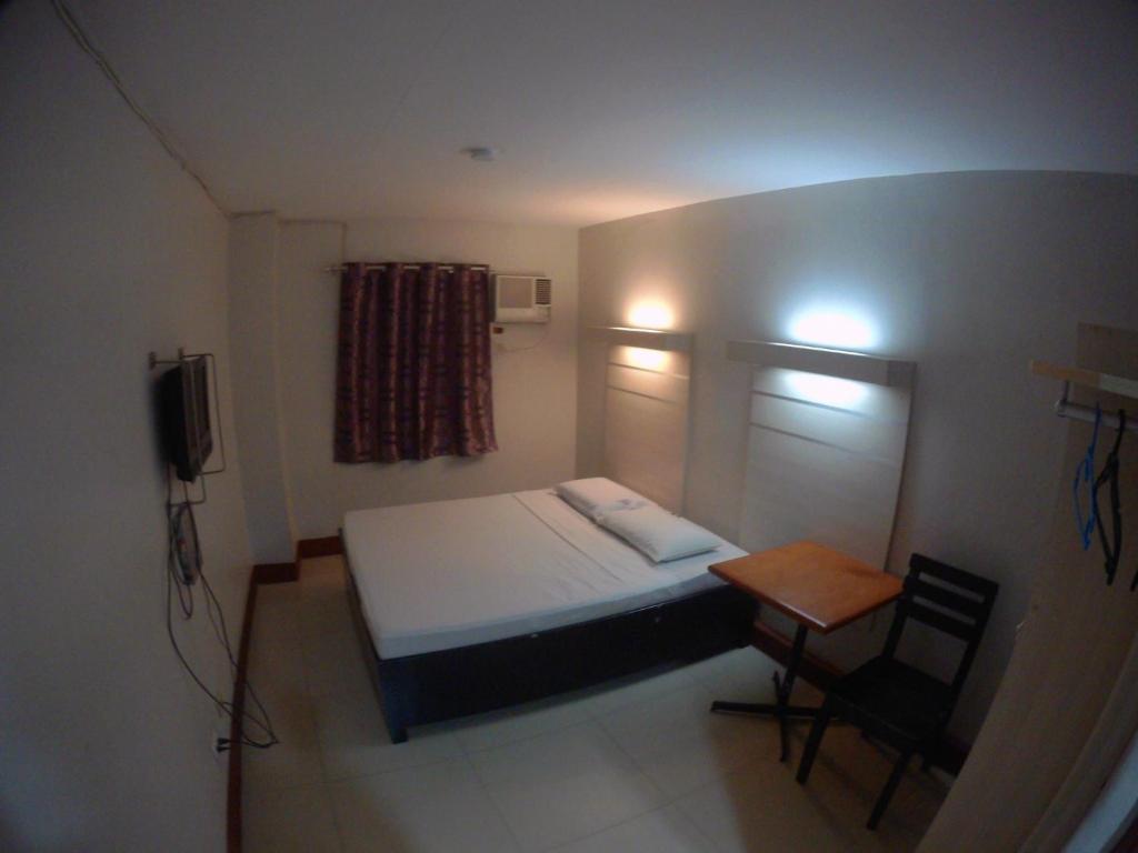 卡加盐德奥罗D' Loft Inn CDO的小房间设有一张床和一张小桌子
