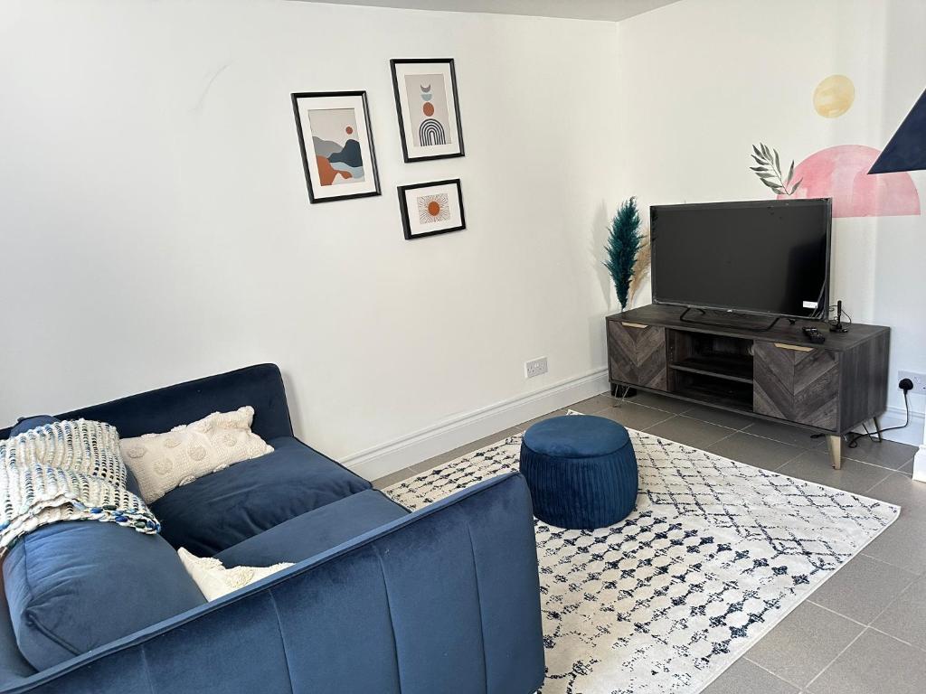 特罗布里奇Cosy One Bedroom Apartment的客厅配有蓝色的沙发和电视