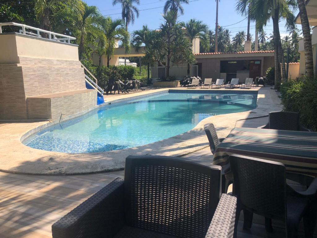 纳瓜坎布里酒店的度假酒店内带桌椅的游泳池