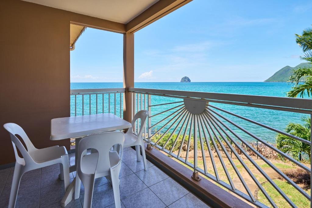 勒迪亚芒Diamant Beach的一个带桌椅的海景阳台