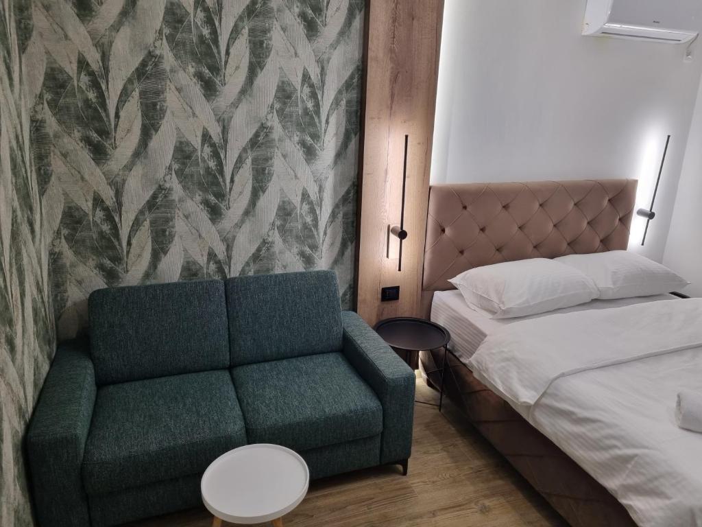 巴尼亚卢卡M Lux Apartments的一间卧室配有绿色的沙发和一张床