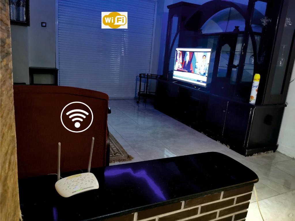 康斯坦丁Appartement F4 de Luxe的客房设有电视和带遥控器的桌子。