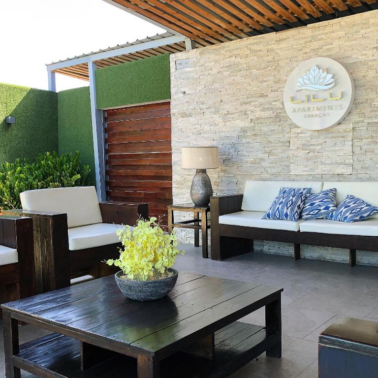 威廉斯塔德Lilu Apartments Curaçao的天井配有2张沙发、1张桌子和1张桌子。