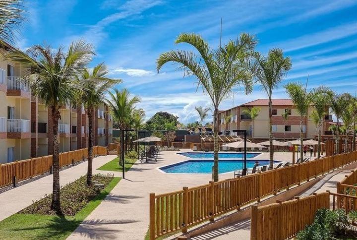 塞古罗港Resort Ondas Praia apart的一个带游泳池和棕榈树的度假村