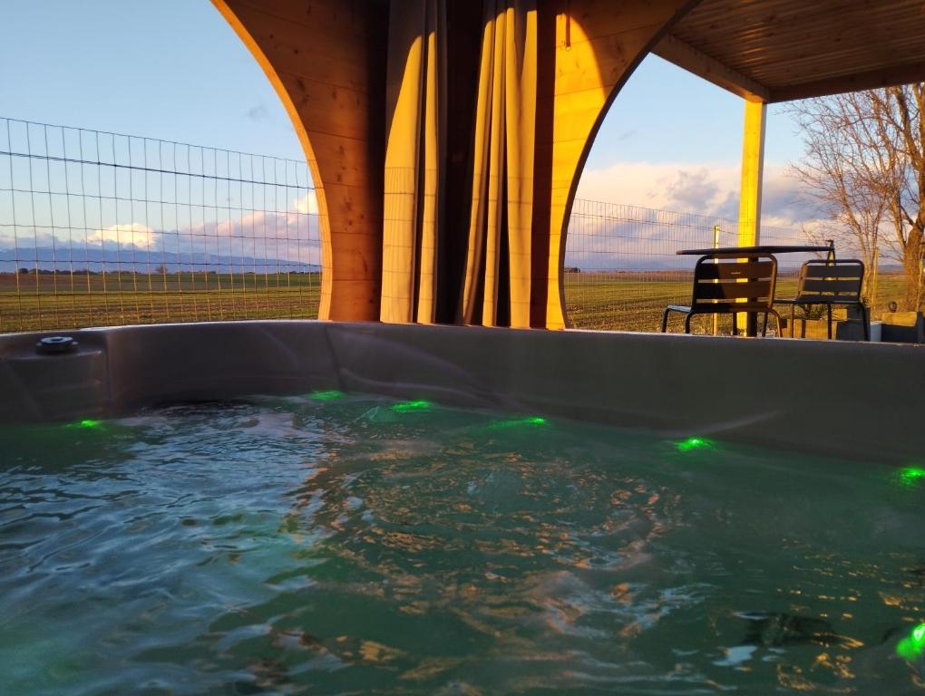 瓦朗索尔Le Spa des lavandes的热水浴池享有桌椅的景致。