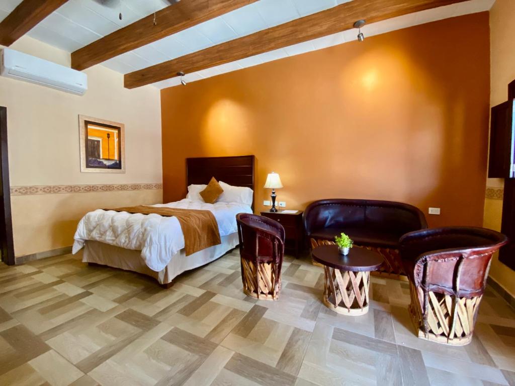 阿拉莫斯Hotel Real de los Alamos的酒店客房,配有床和椅子