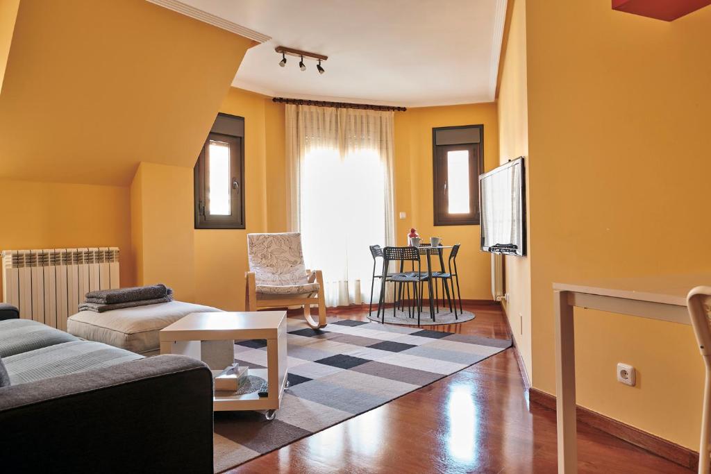 莱昂Apartamento La Calma, plaza de La Inmaculada, en el centro de León的客厅设有黄色的墙壁、沙发和电视
