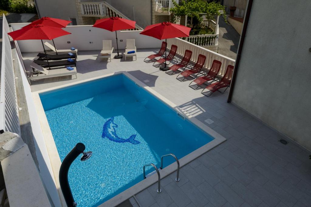 察夫塔特宾果别墅酒店的一座大楼内的游泳池,配有椅子和遮阳伞