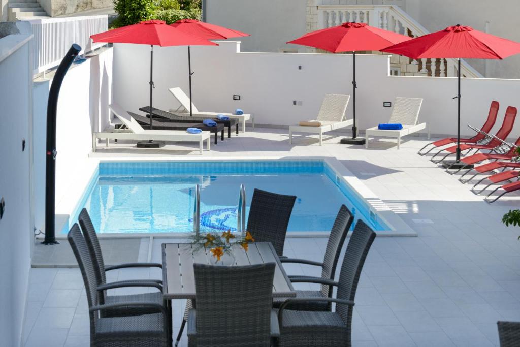 察夫塔特宾果别墅酒店的一个带桌椅和遮阳伞的游泳池