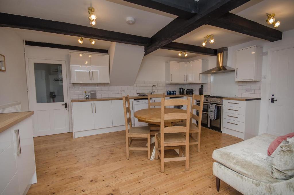 布里斯托Hideaway Cottage的厨房配有白色橱柜和桌椅