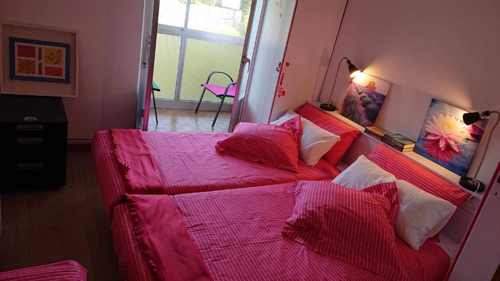 MiravallesPiso Rio Nervión 15 Minutos Bilbao的一间卧室配有一张带粉色床单和枕头的床。