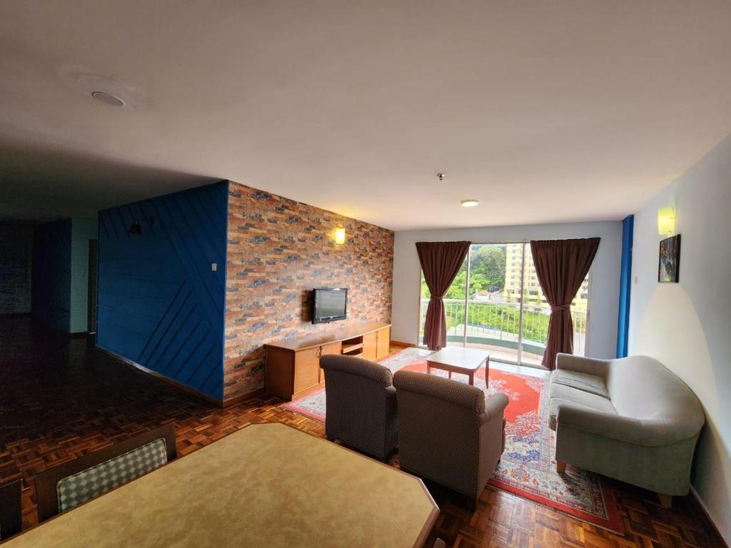 金马仑高原Little Star Hotel & Apartments的客厅配有沙发、椅子和电视