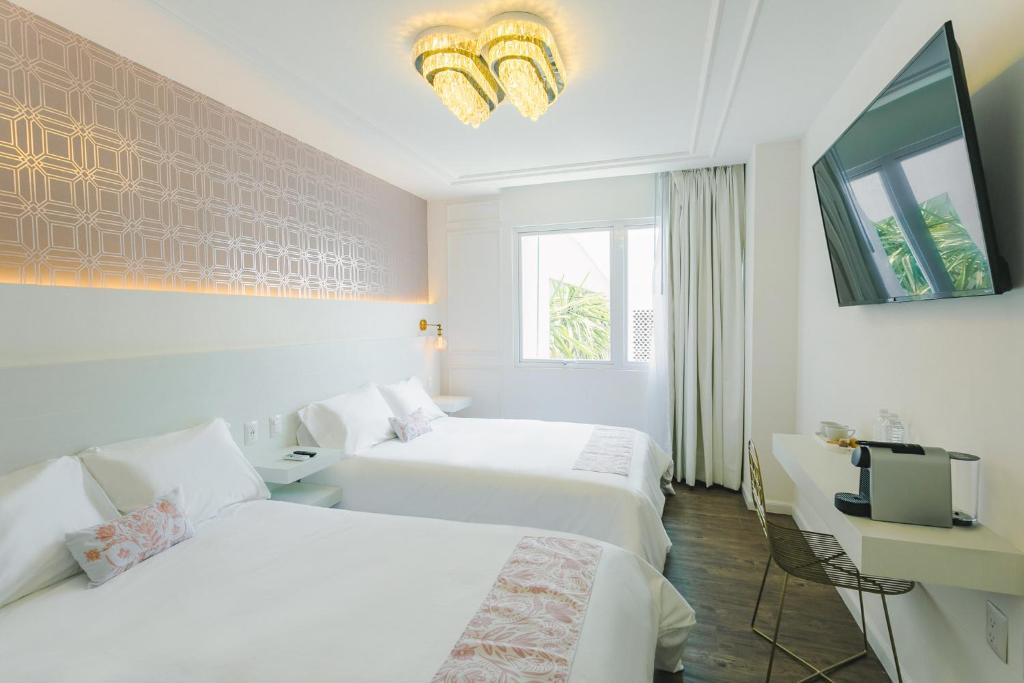 克雷塔罗Casa Oxa Hotel的酒店客房设有两张床和电视。