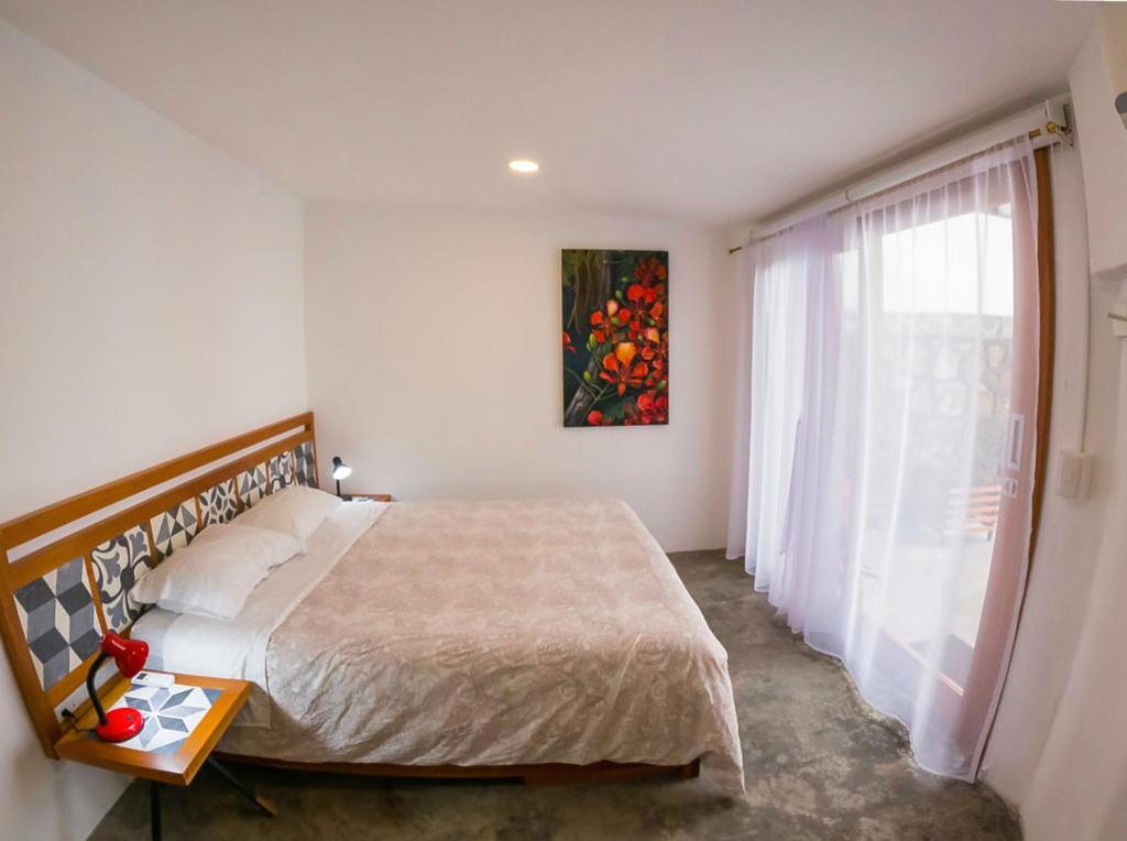 阿约拉港La K-leta Boutique Guesthouse的一间卧室设有一张大床和一个窗户。