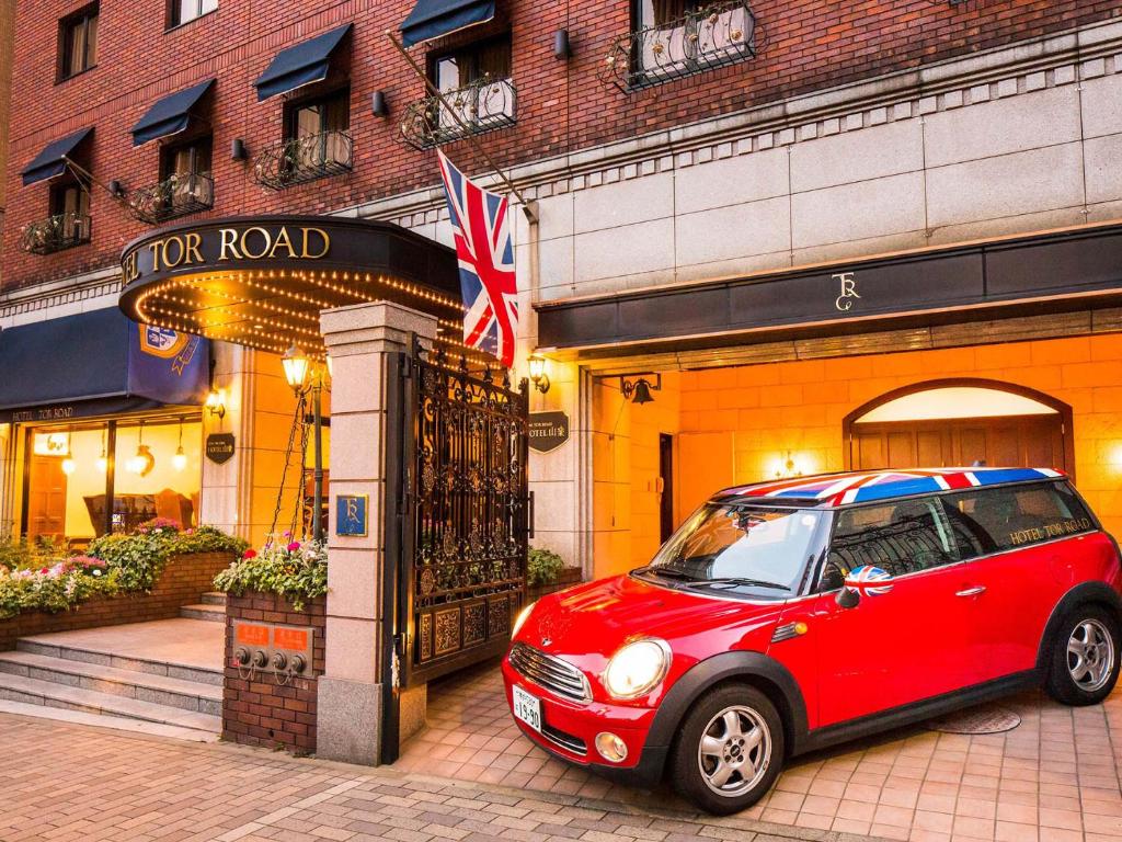 神户神户山乐TOR ROAD 酒店的停在大楼前的红色小汽车