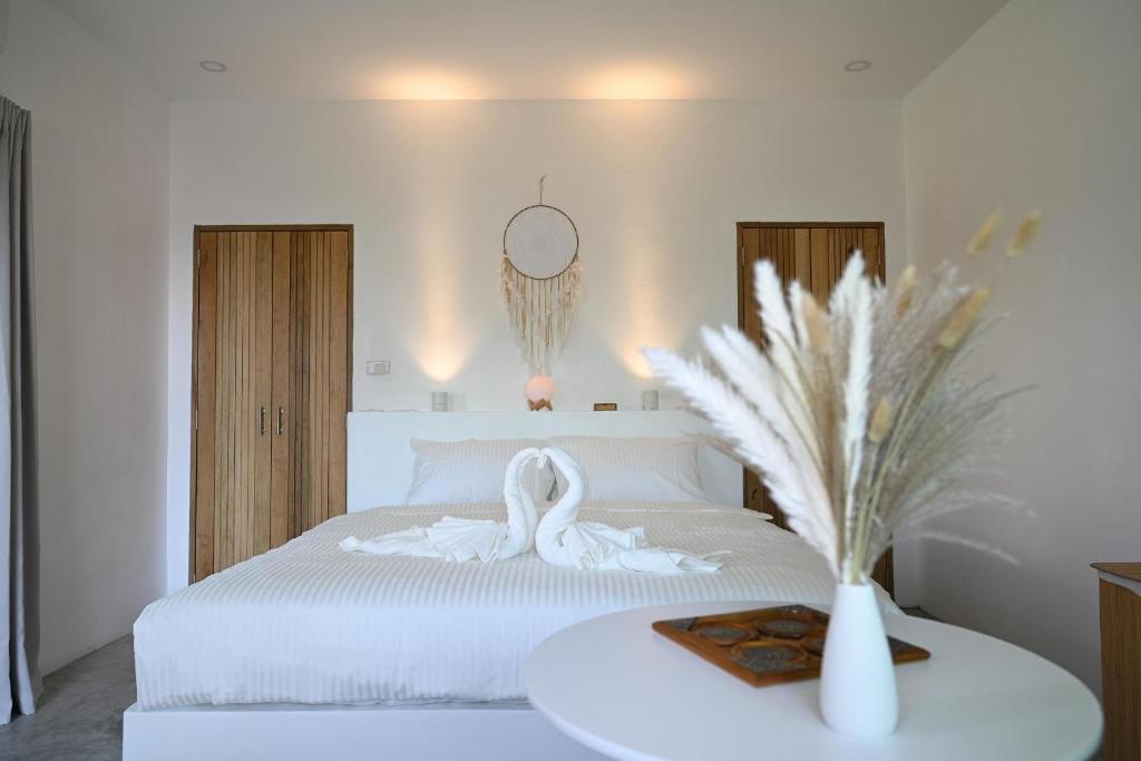 哈德姚Bao Village的卧室配有白色床和白色天鹅