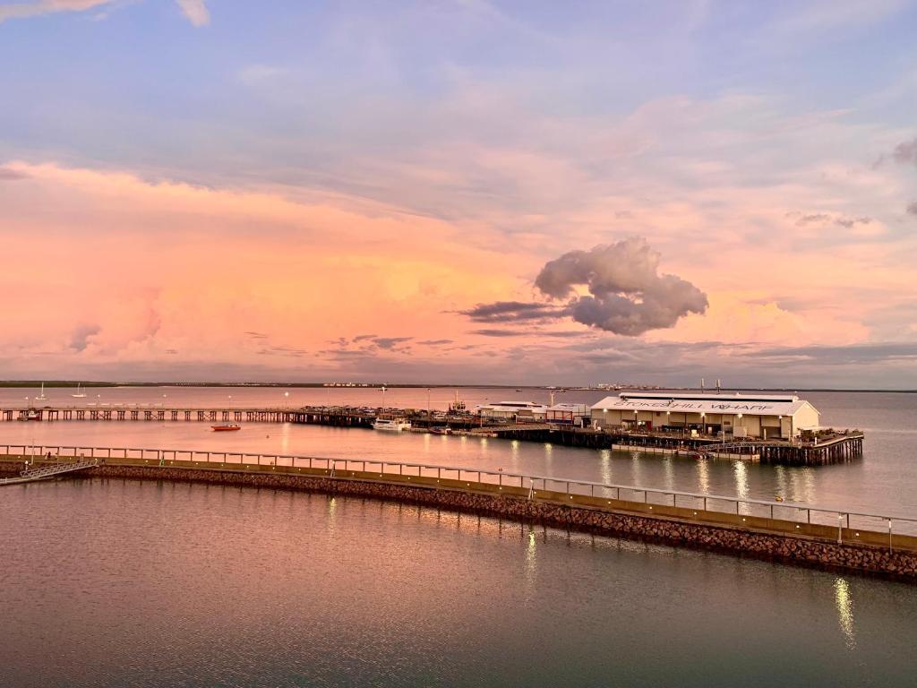 达尔文Absolute Waterfront - Tropical Sunrise Apartment Over The Water的水面上的码头,天空阴云