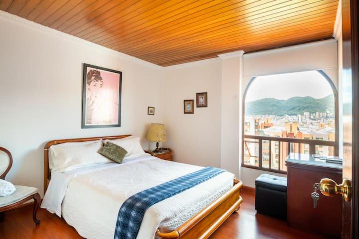 波哥大Habitaciones en un alojamiento -Anfitrion - Elias Di Caprio的一间卧室设有一张床和一个大窗户