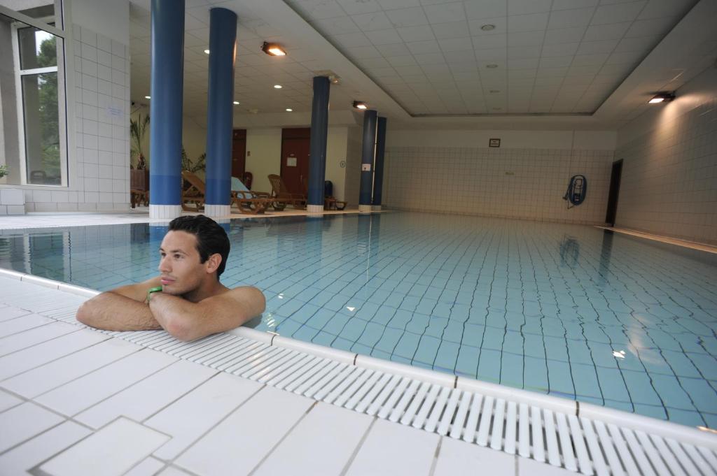奥尔贝VVF Alsace Orbey Colmar的躺在游泳池地板上的男人