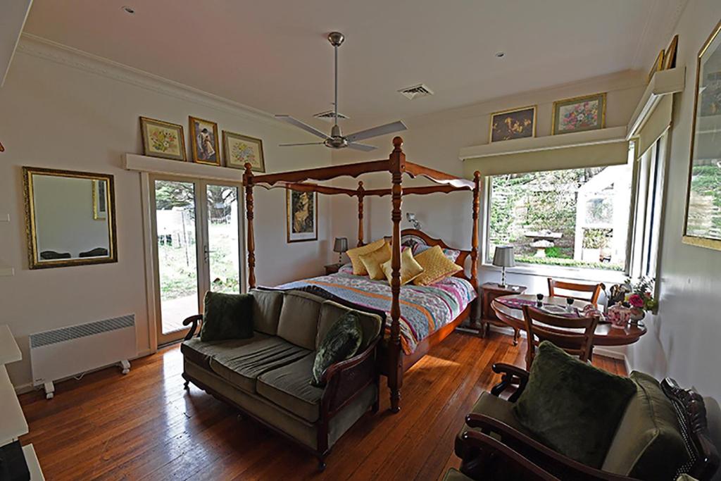 吉斯伯恩Galahad's Animal Sanctuary B&B的一间卧室配有天蓬床和沙发