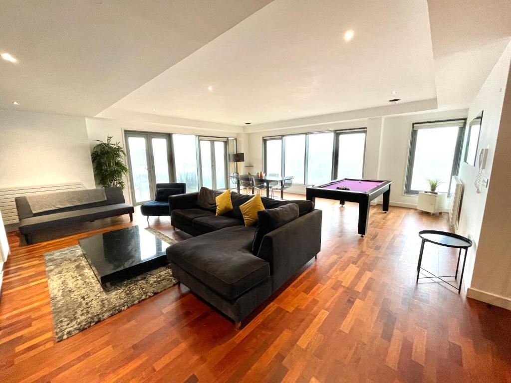 泰恩河畔纽卡斯尔Newcastle Penthouse - Sleeps 8 - City Centre - Free Parking - City Views的客厅配有沙发和桌子