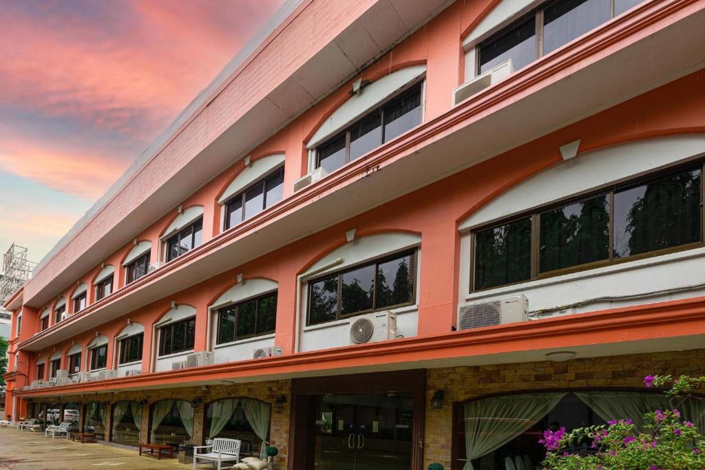 曼谷PJ水门酒店的一座橙色的建筑,有很多窗户