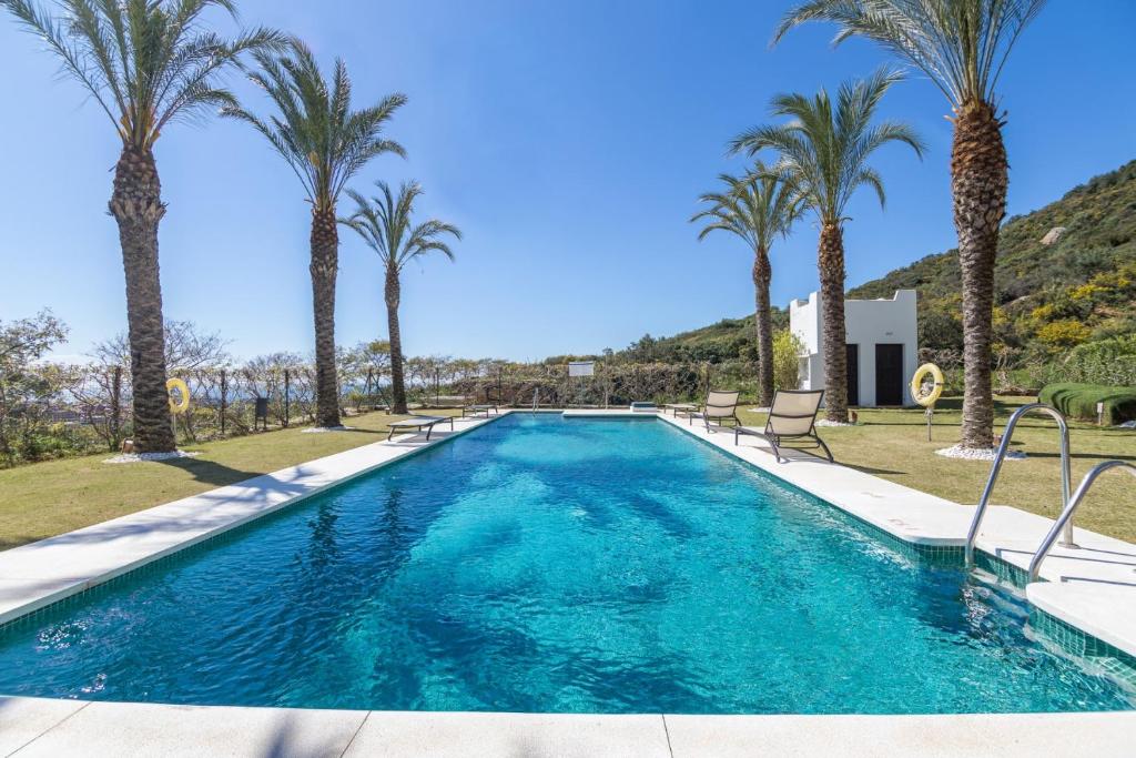 卡萨雷斯2156-Luxury apt in Cortesin golf with pool view的一座棕榈树环绕的游泳池